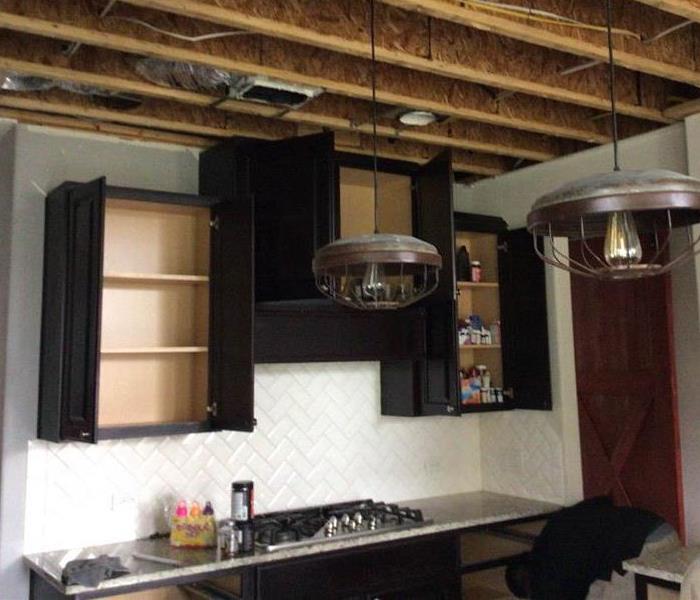 Black kitchen cabinets replaced after restoration.